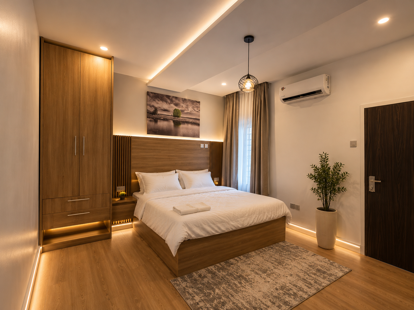 Bedroom in the Aston Gaduwa home with a double bed, fitted wardrobe, air conditioning and warm lighting