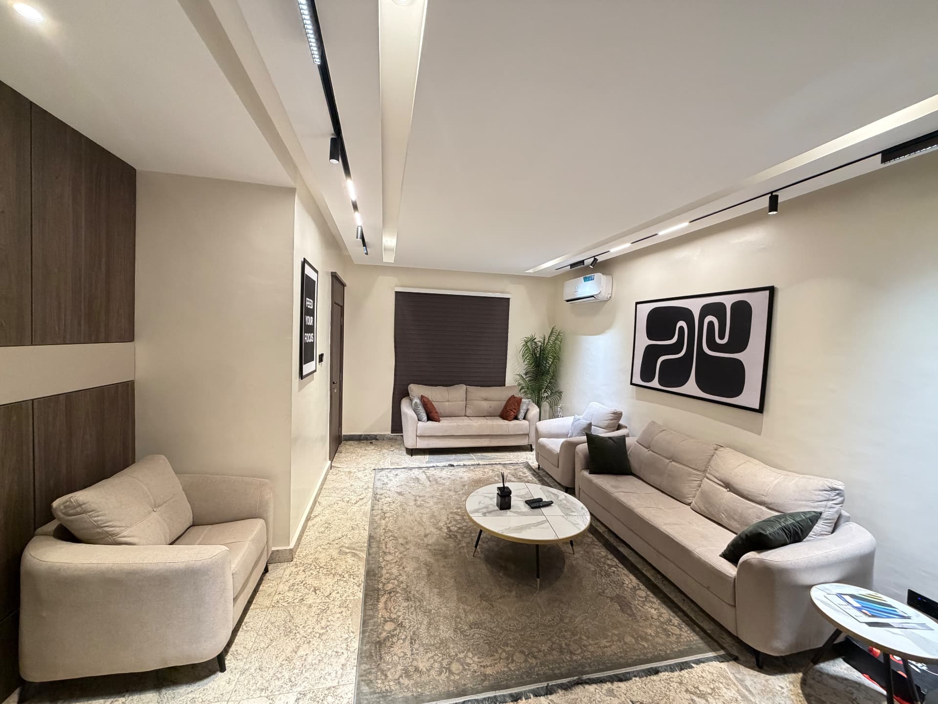 Wide view of the furnished living room in the Aston private one-bedroom apartment at Legislative Quarters, Abuja