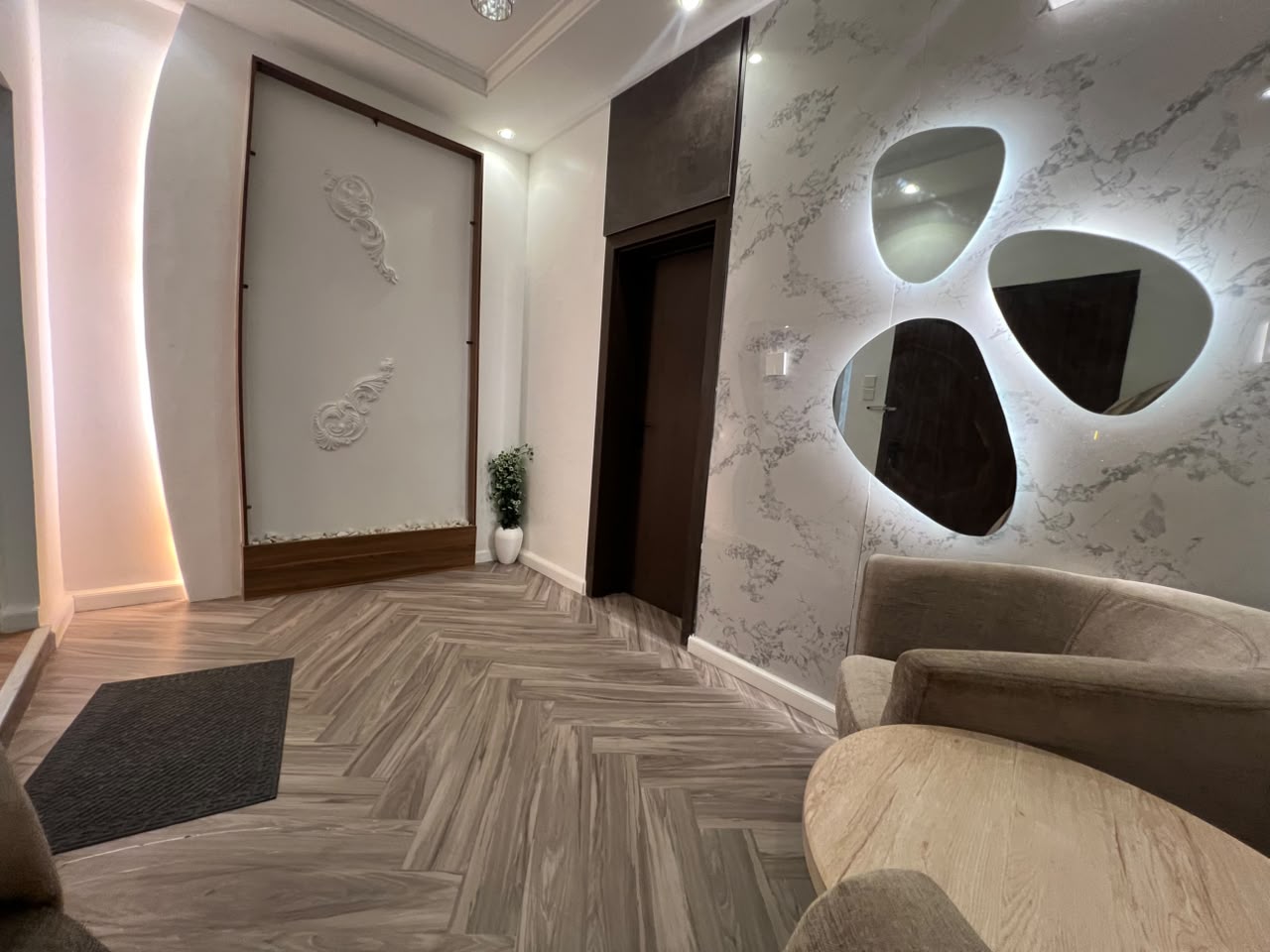 Entrance hallway of the Aston shared residence with seating and a feature mirror wall
