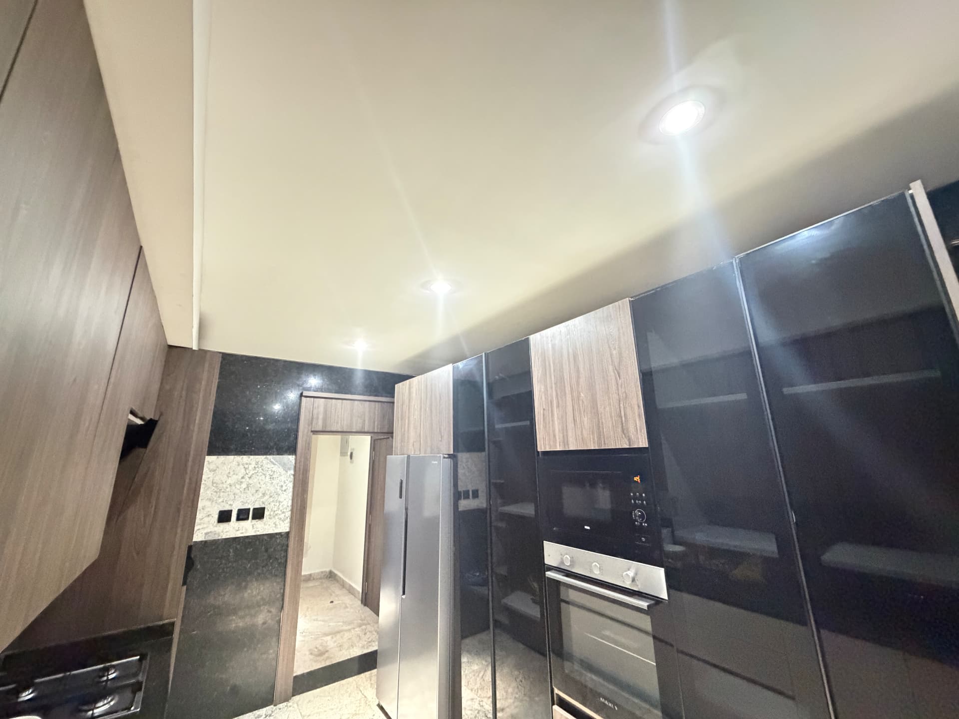 Second view of the fitted kitchen showing the hob, cabinetry and appliances