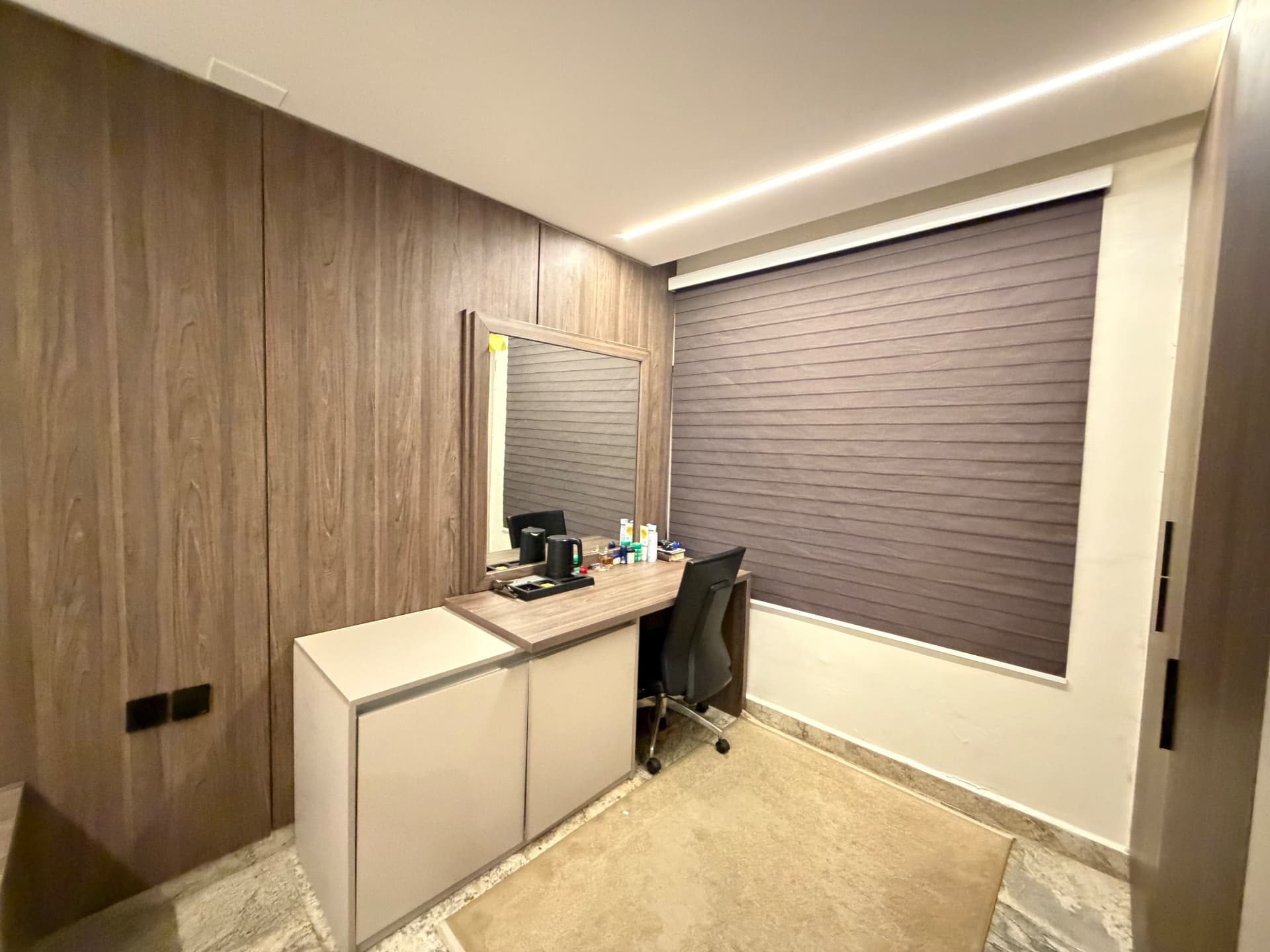 Work area in the bedroom with a desk, chair, mirror and storage