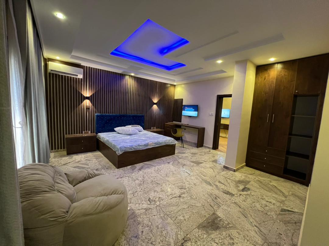 Presidential Suite showing the fitted wardrobe and storage, with the sleeping area and desk beyond